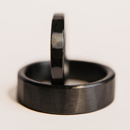 Black Zirconium Wedding Band Set. This photo shows two lightly faceted black zirconium rings. (smaller ring is on top of larger ring)