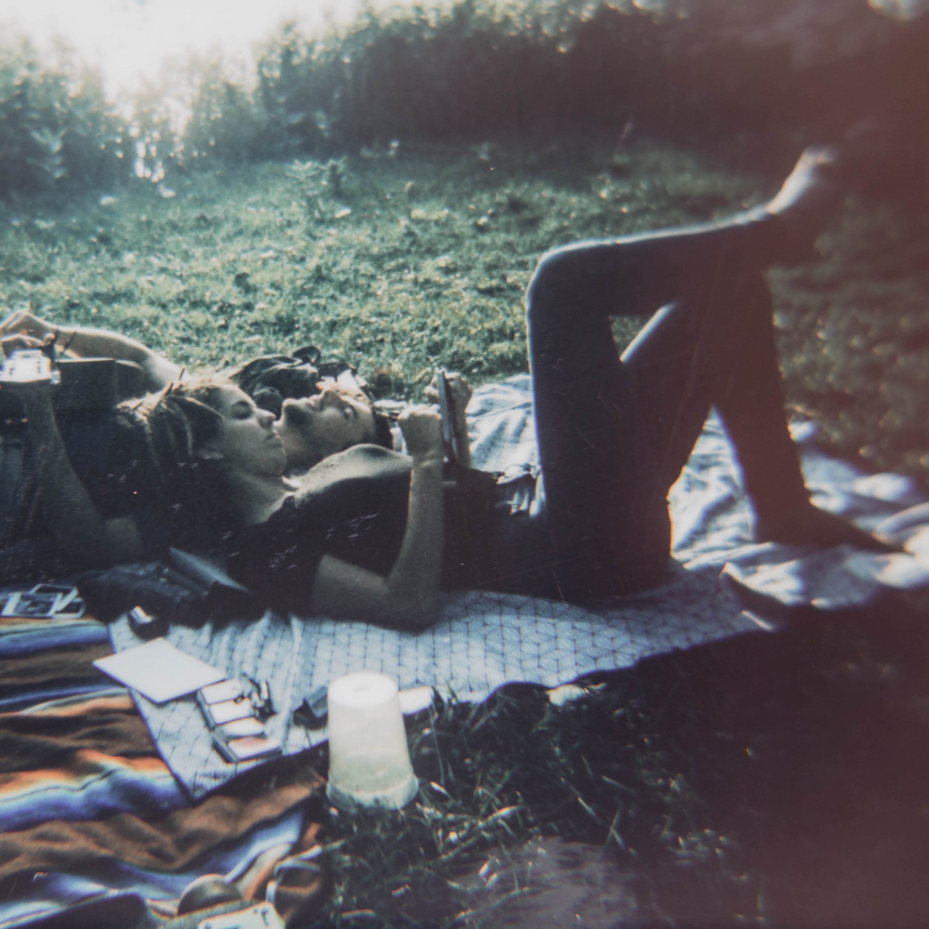 Two people laying on blanket in park