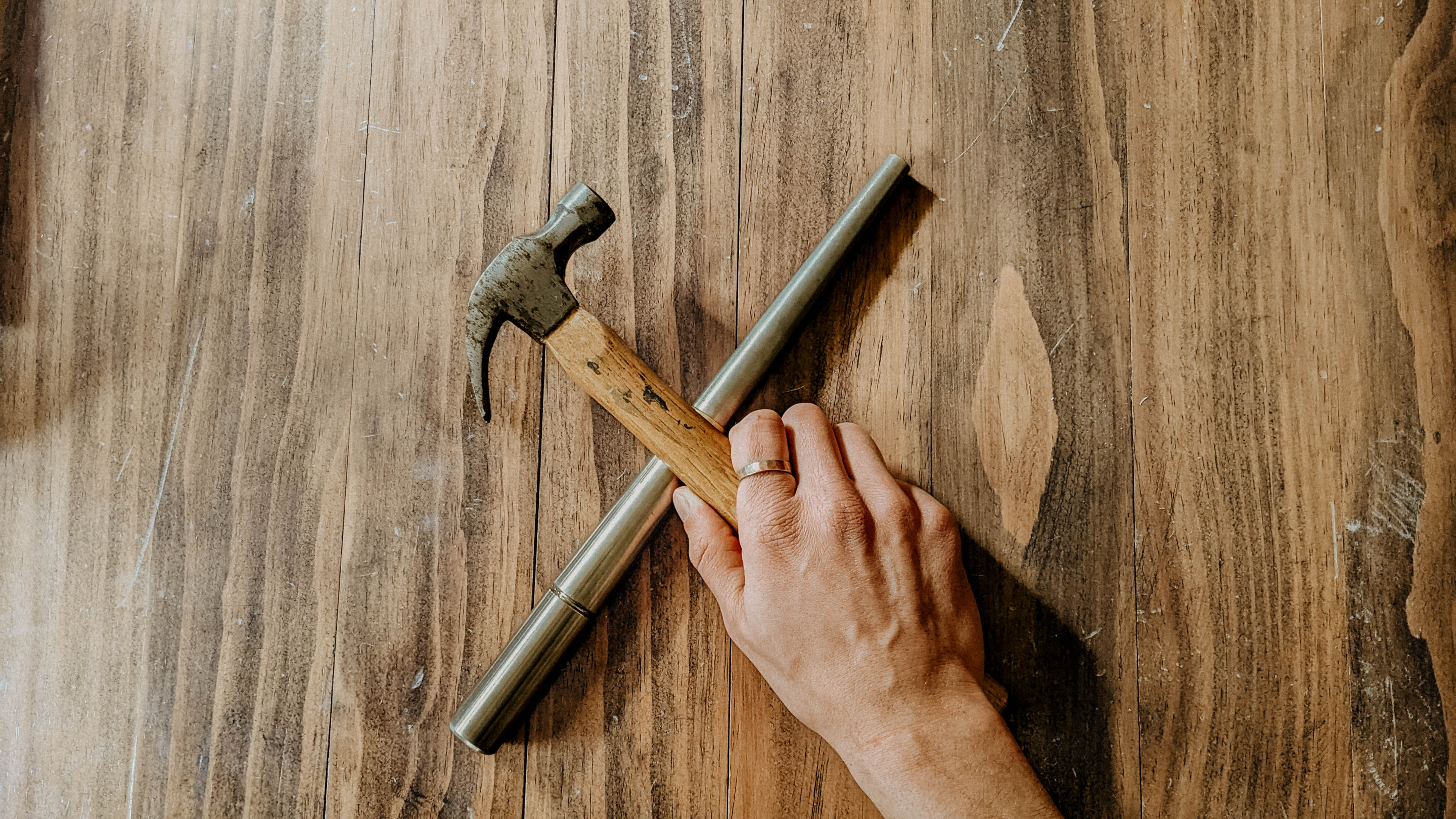 Hand holding a hammer across a ring mandrel