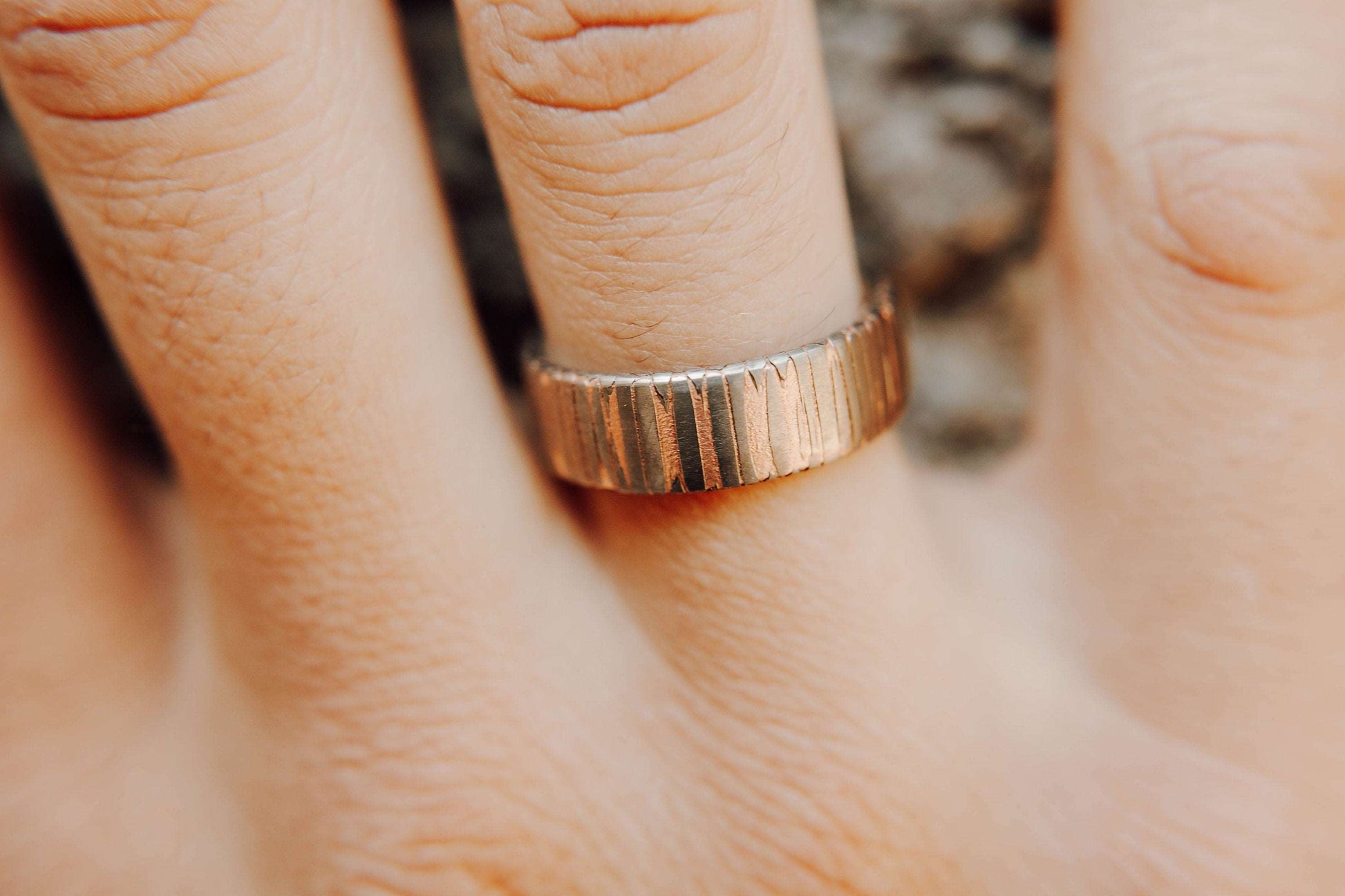 Superconductor wedding band. This photo shows an etched titanium-niobium and copper striped ring with silver liner. (Shown on finger))