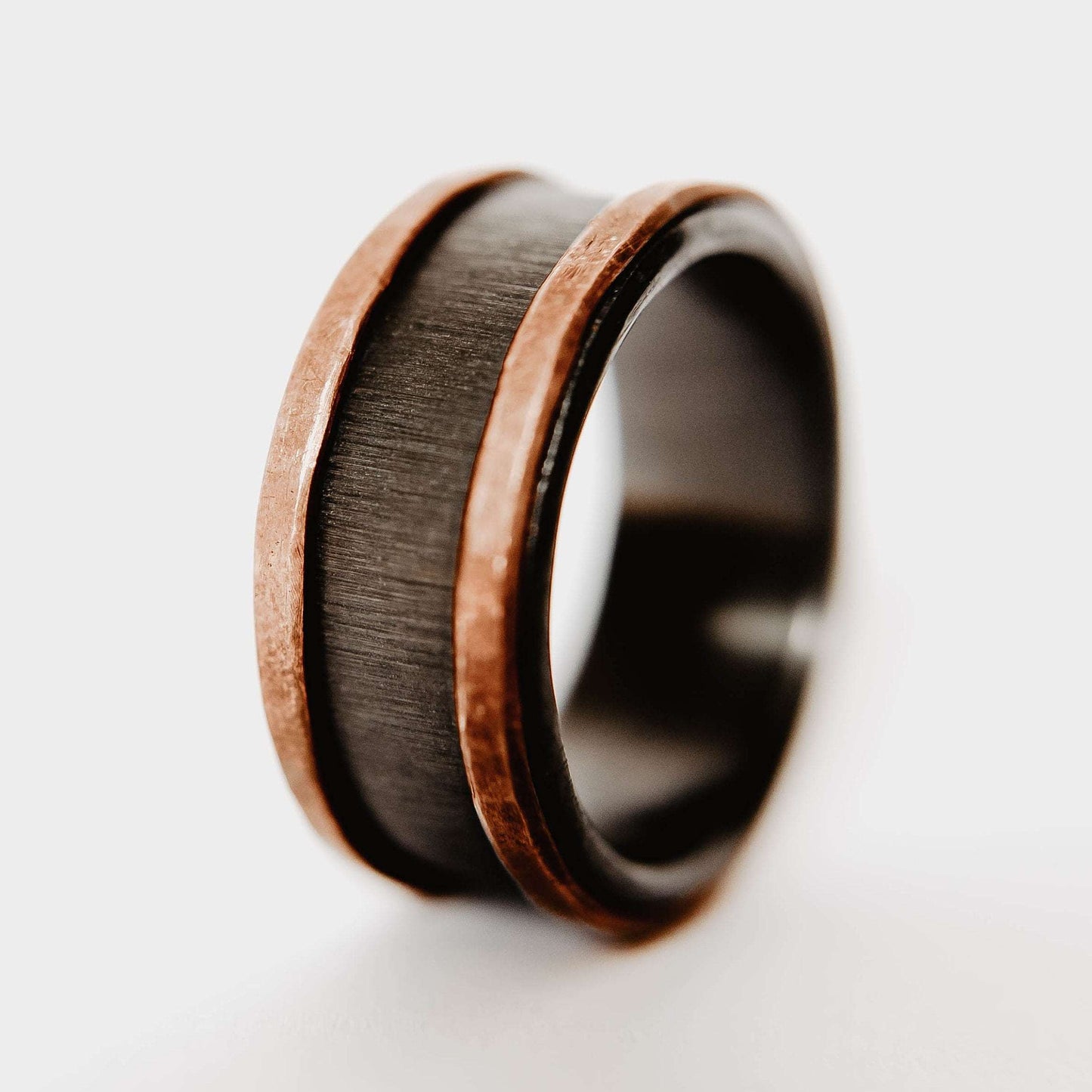 Mens zirconium and copper wedding band. This photo shows a vertical grit zirconium band with a copper band on each edge. (Vertical with white background)