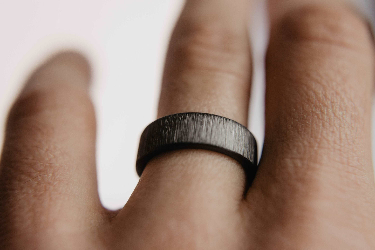 Vertical Grit Zirconium Mens Wedding band. This photo shows a vertical grit zirconium band. (Shown on finger)