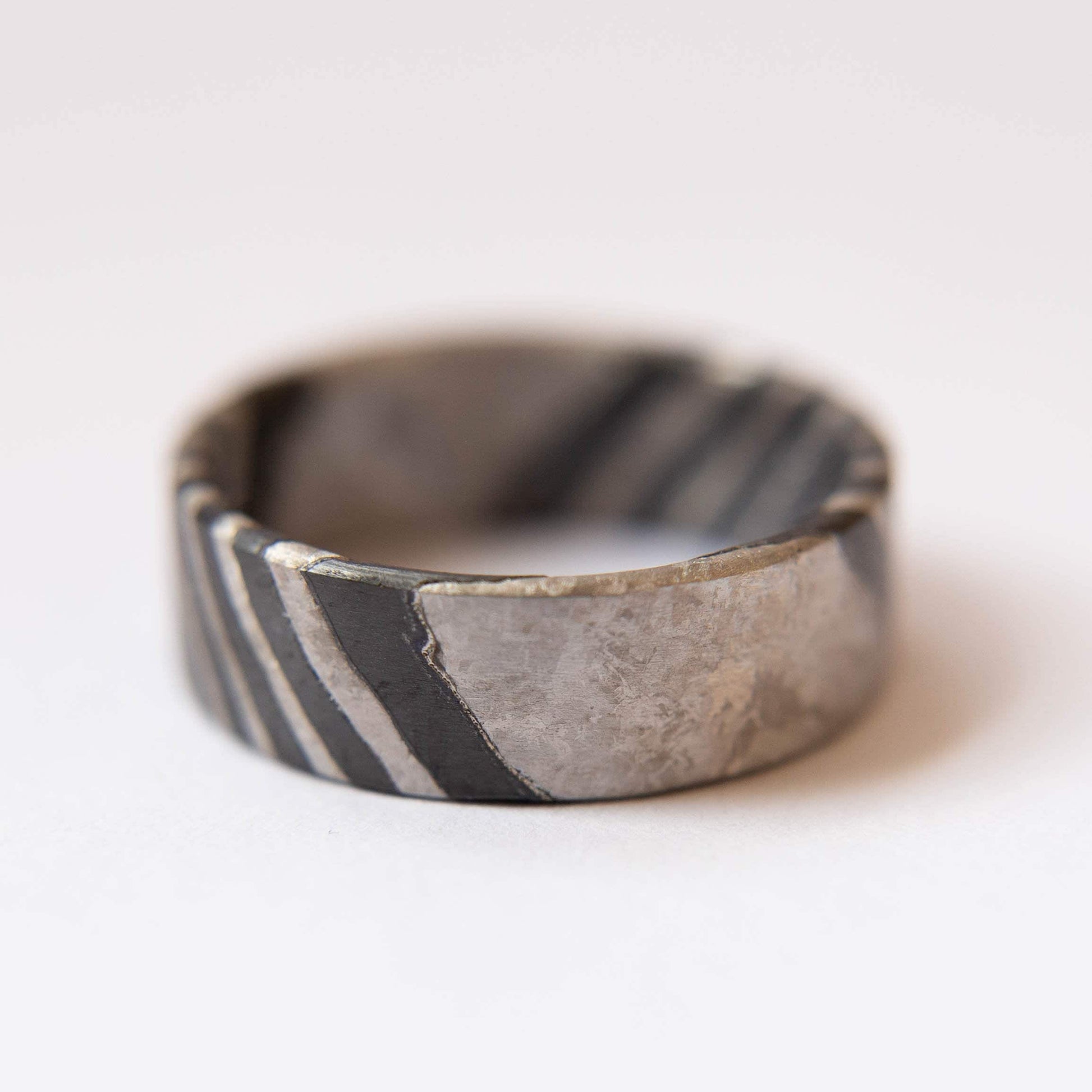 Black Zirconium and Crystallized Titanium Damascus Wedding Band. Black and Silver Ring. (Horizontal with white background)