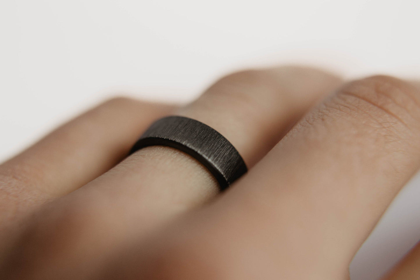 Vertical Grit Zirconium Mens Wedding band. This photo shows a vertical grit zirconium band. (Shown on finger)