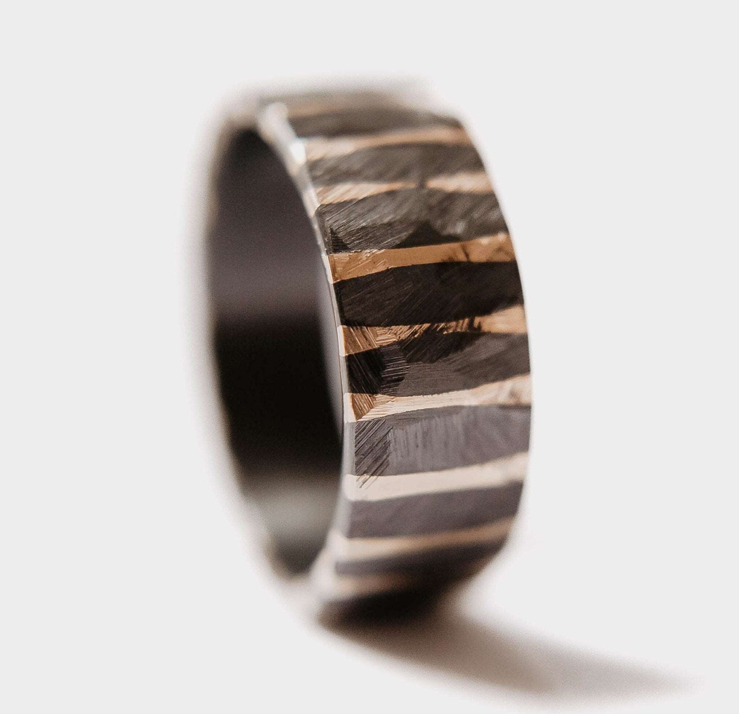 Gold Twilight Wedding Band. This photo shows a roughly faceted zirconium wedding band with 14k gold stripes (Vertical with white background)