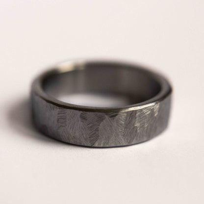 Distressed titanium wedding band. This photo shows a gritty faceted gray titanium ring. (Horizontal with white background)