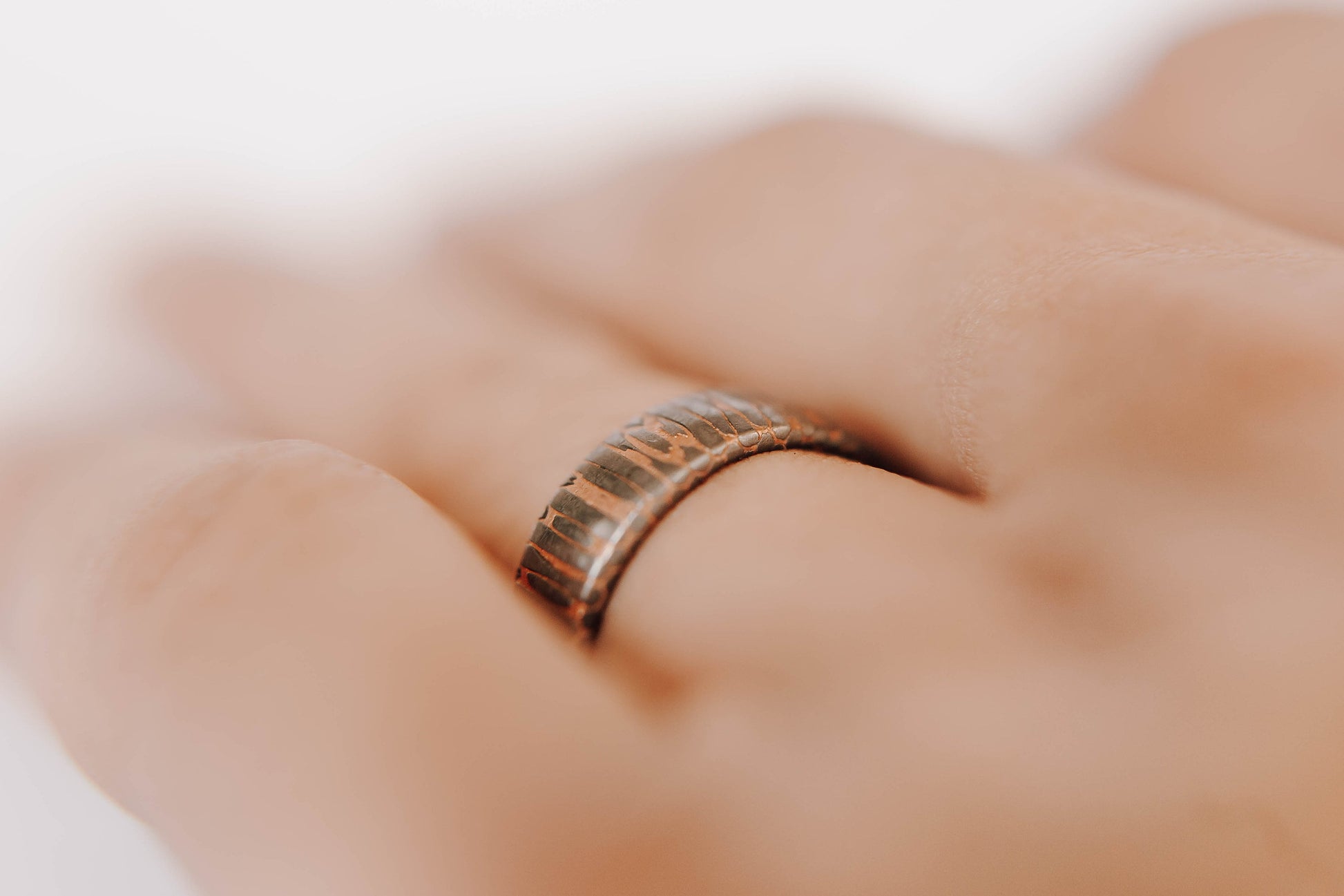 Superconductor wedding band. This photo shows an etched titanium-niobium and copper striped ring. (Shown on finger)