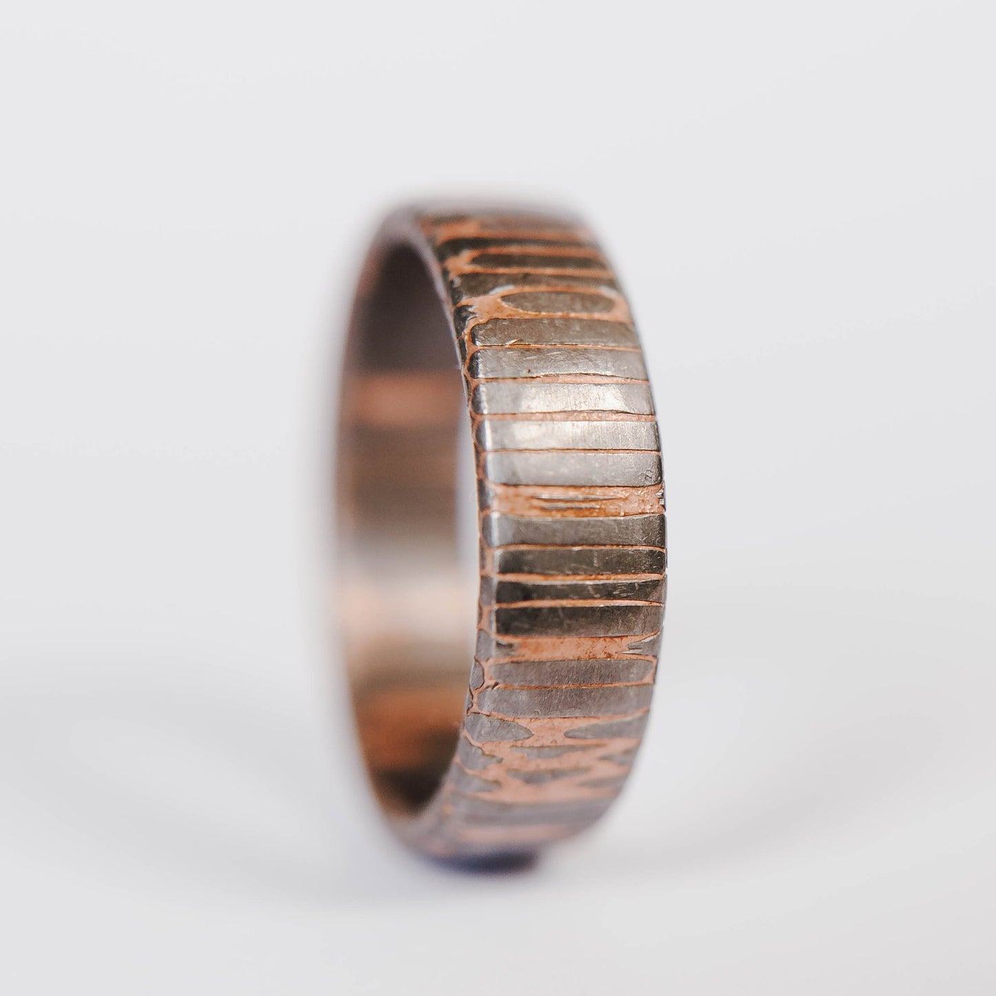 Superconductor wedding band. This photo shows an etched titanium-niobium and copper striped ring. (Vertical with white background)