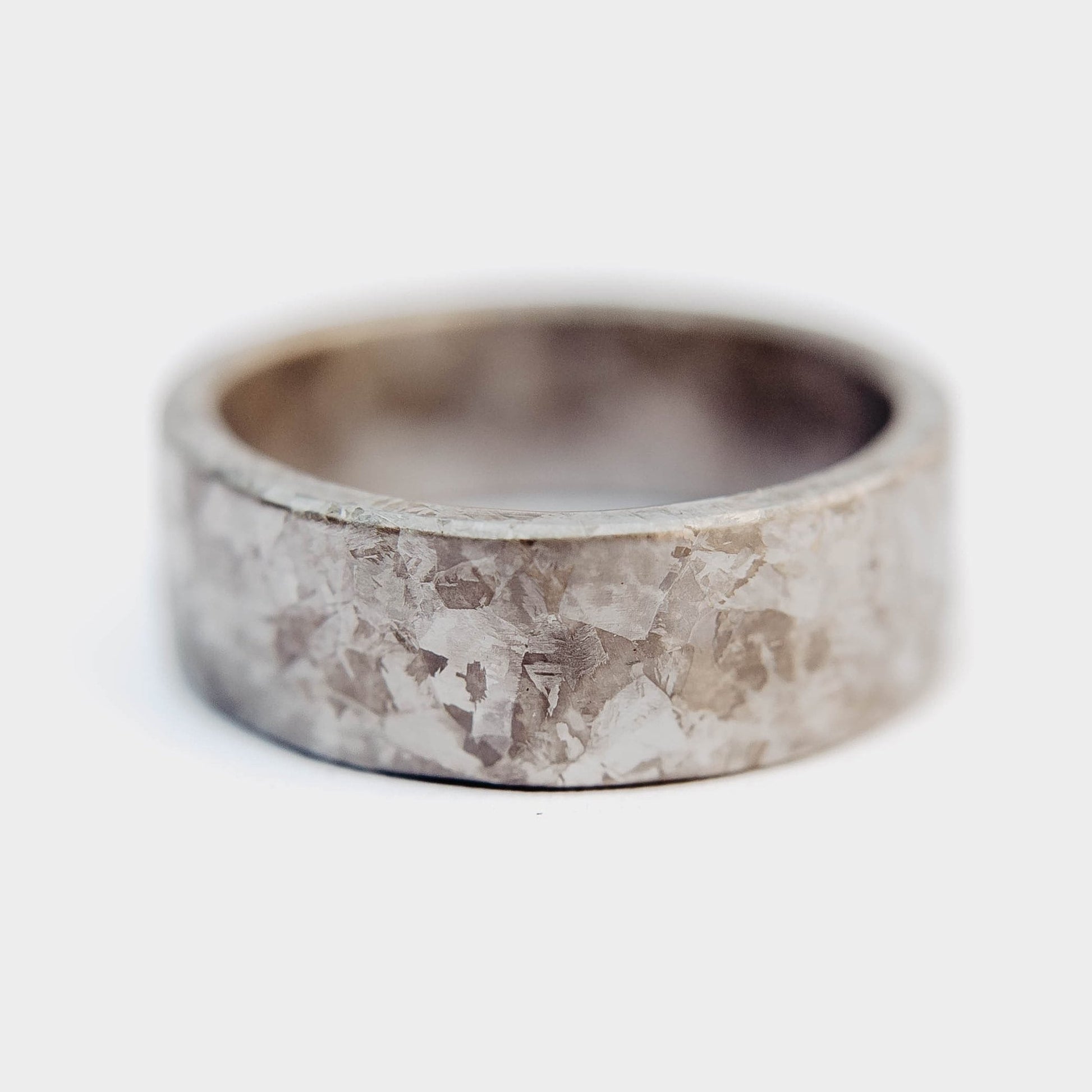 Crystallized Titanium Wedding Band. Gray titanium ring with crystallized surface. (Horizontall with pine sprig background)