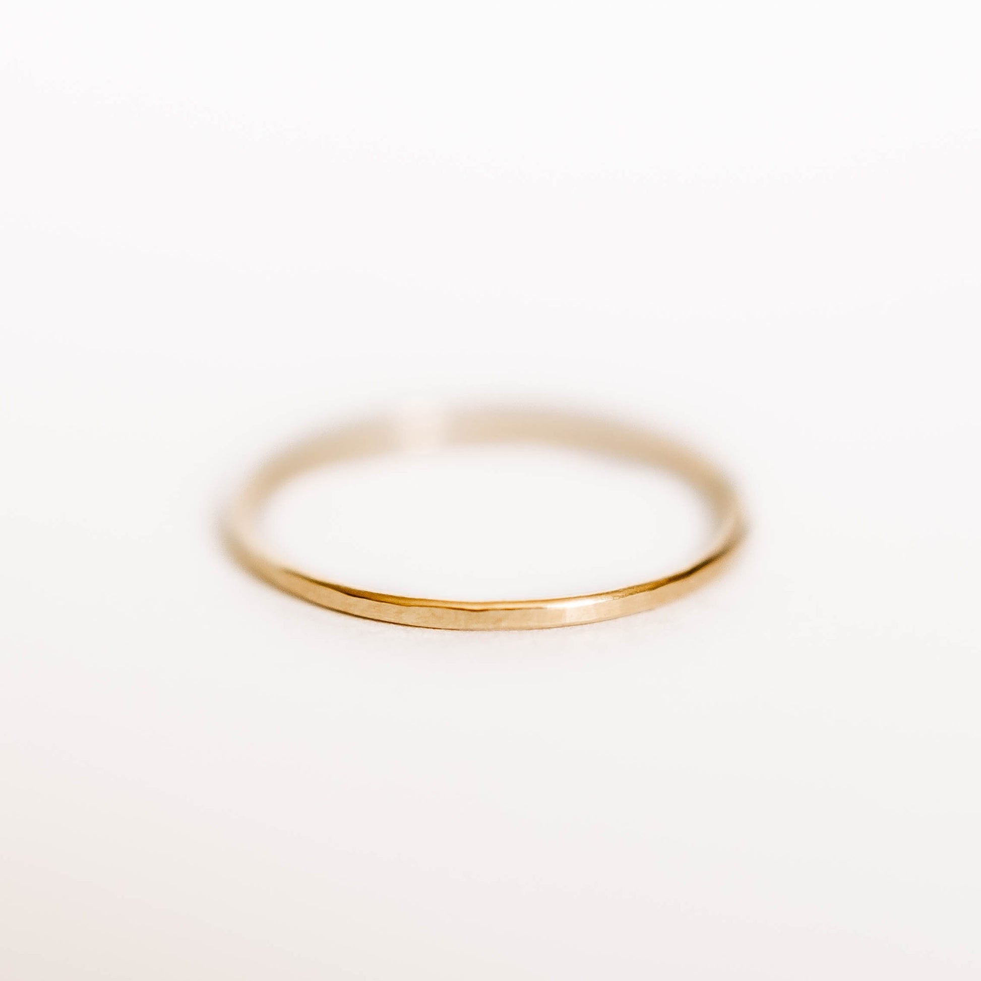 Womens Hammered Gold Wedding Band. This photo shows a dainty hammered 14k gold ring. (Horizontal with white background))