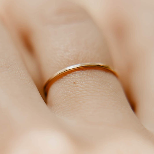 Womens Hammered Gold Wedding Band. This photo shows a dainty hammered 14k gold ring. (Shown on finger)