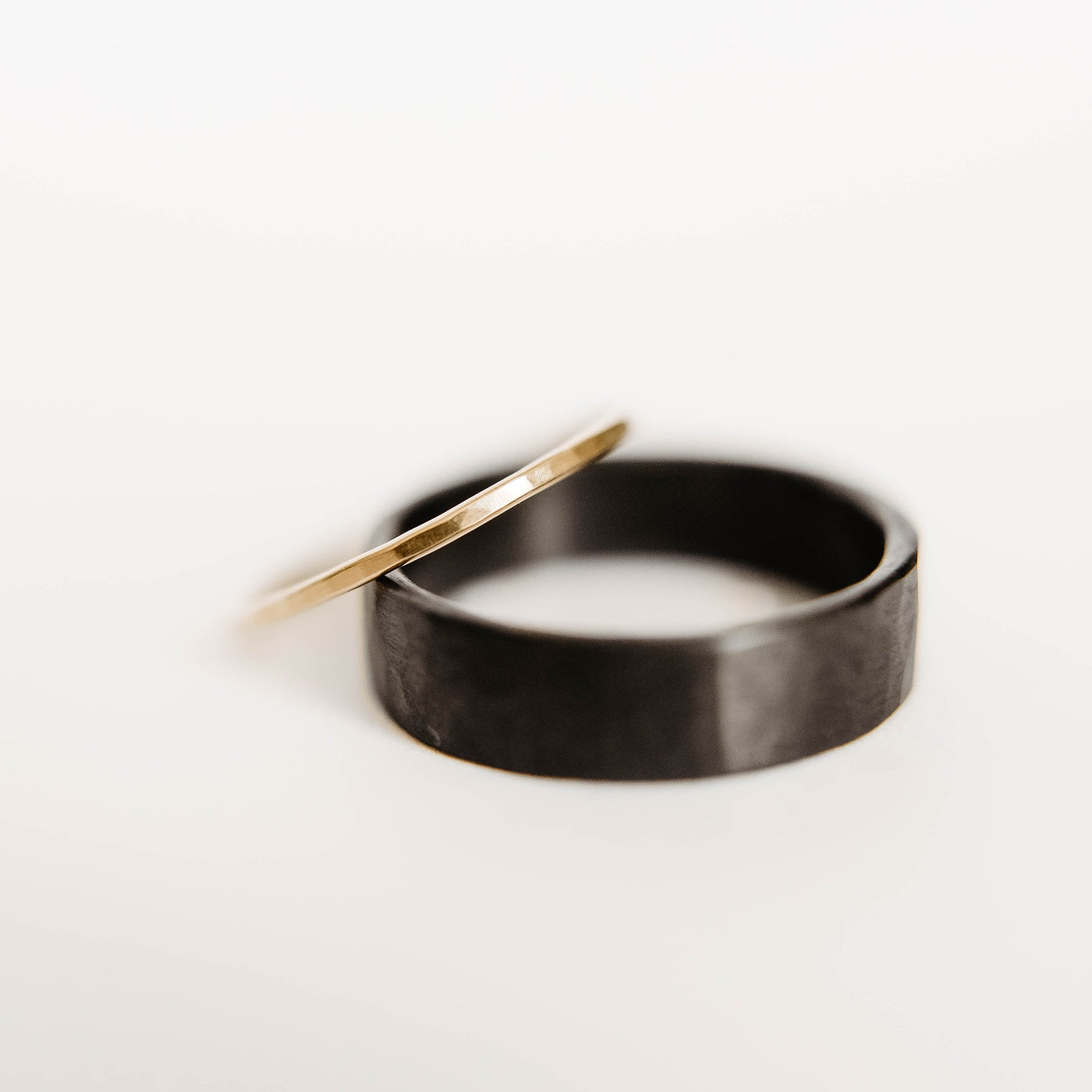 Womens Hammered Gold Wedding Band. This photo shows a dainty hammered 14k gold ring. (Shown on black ring with white background)