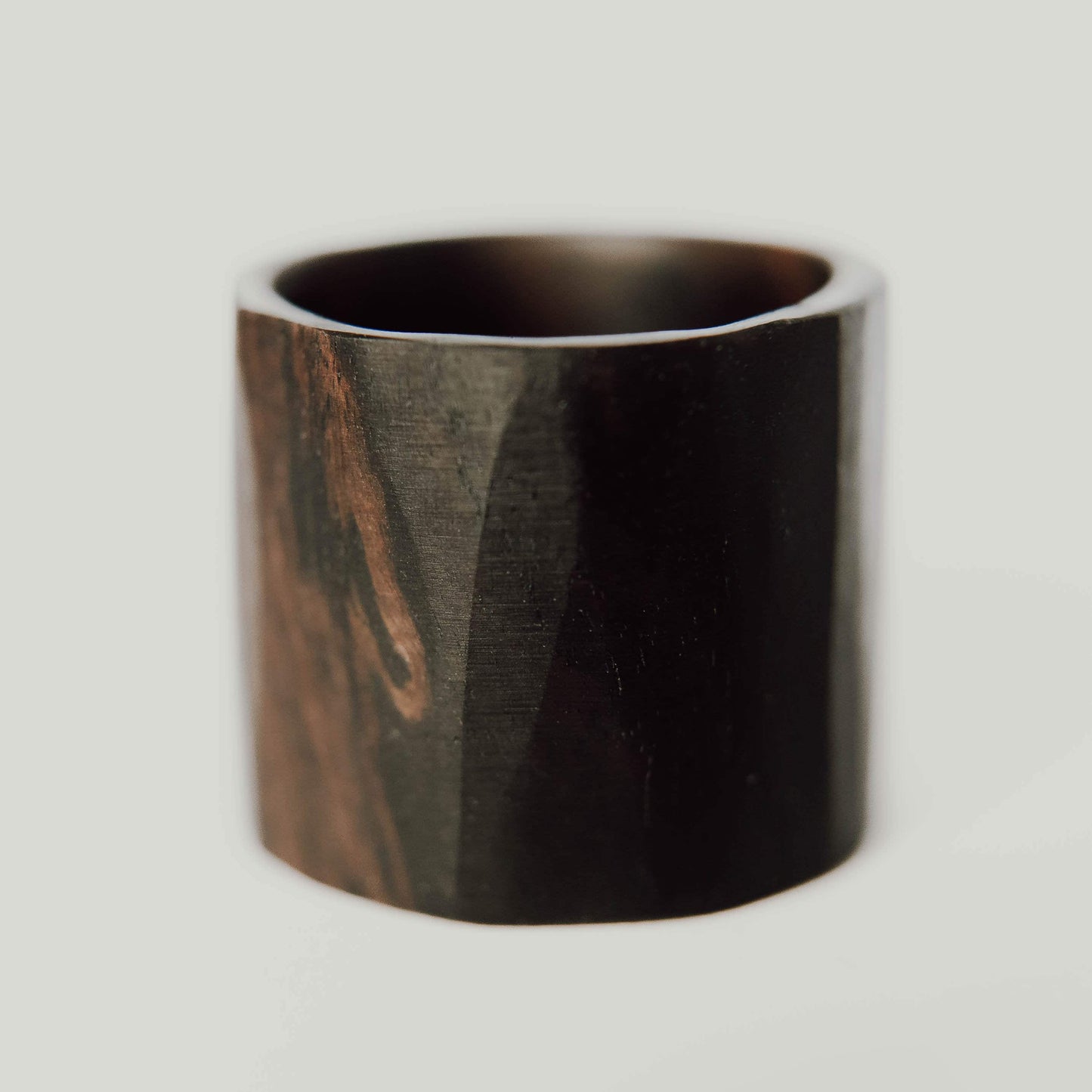 African Blackwood Ring, Dark lightly faceted wide wood ring. (Horizontal with white background))